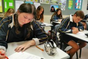 Students sitting at tables in a classroom doing schoolwork